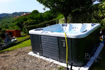 Vasca idromassaggio da esterno installata in giardino con vista panoramica.